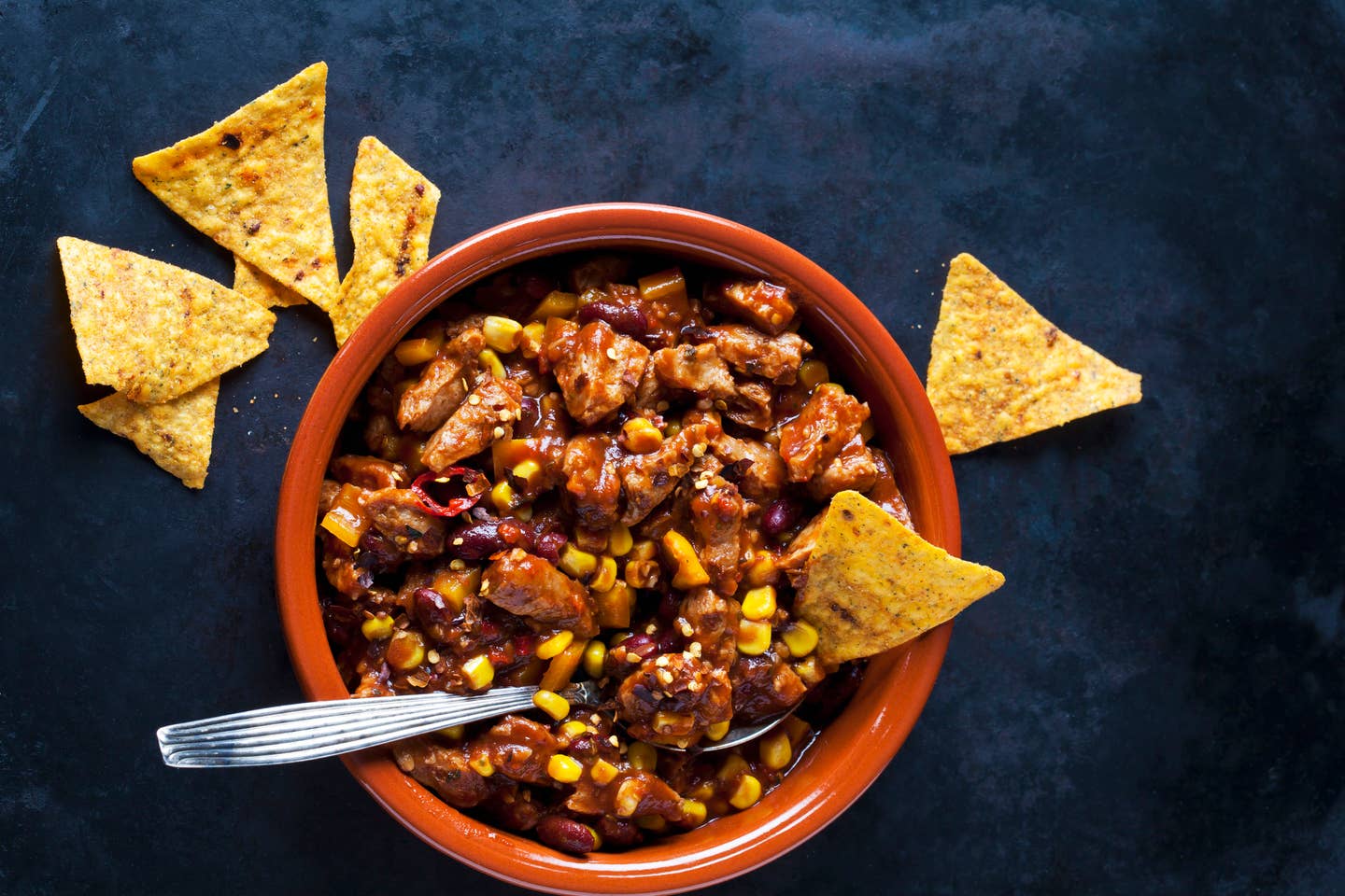 Vegetarian Chili with soy meat cut into strips and tortilla chips in earthenware dish