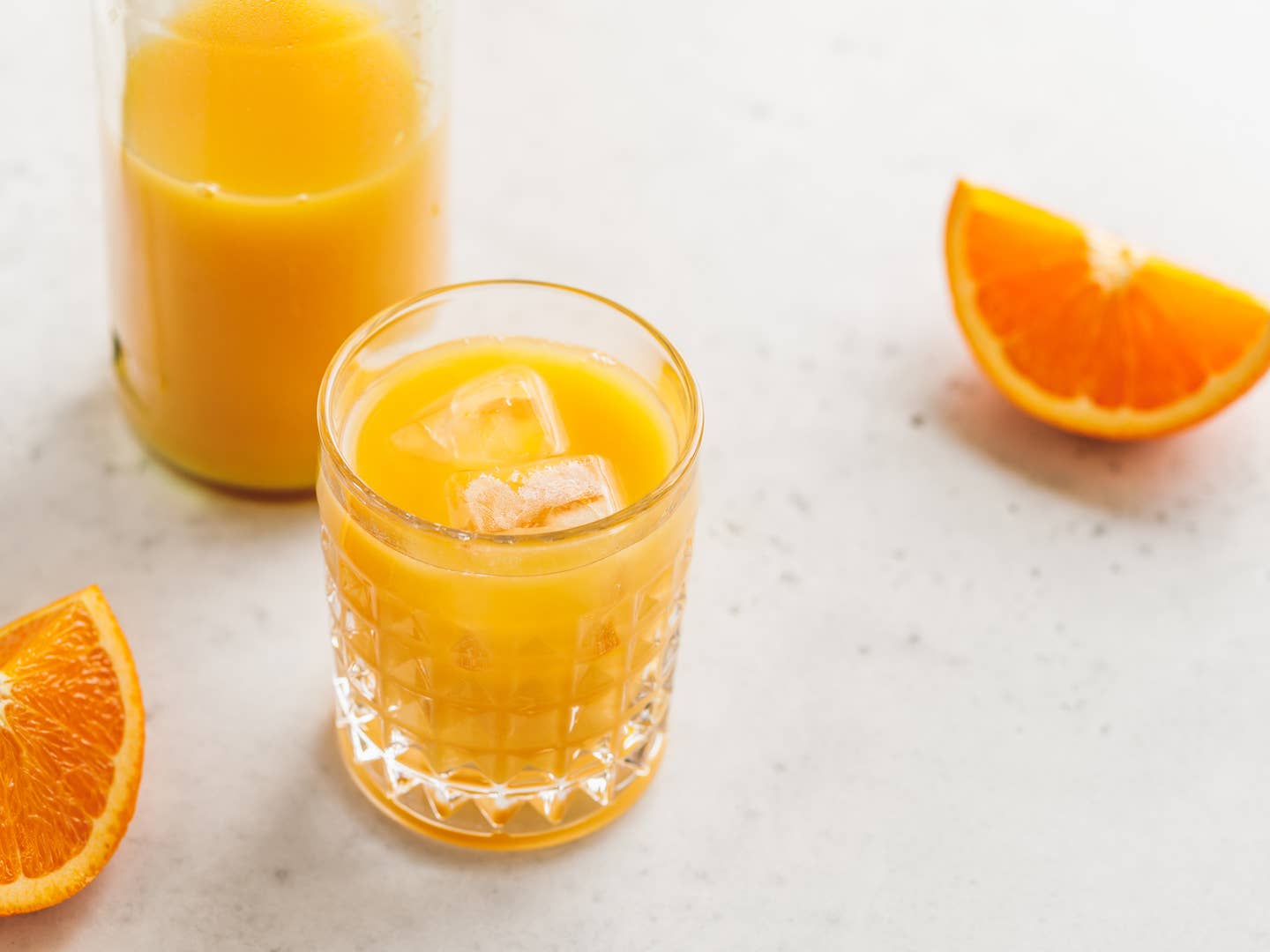 Fresh orange juice with ice cubes in a glass on a table. The concept of healthy eating.