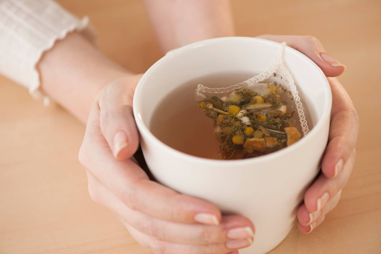 Woman holding cup with chamomile tea