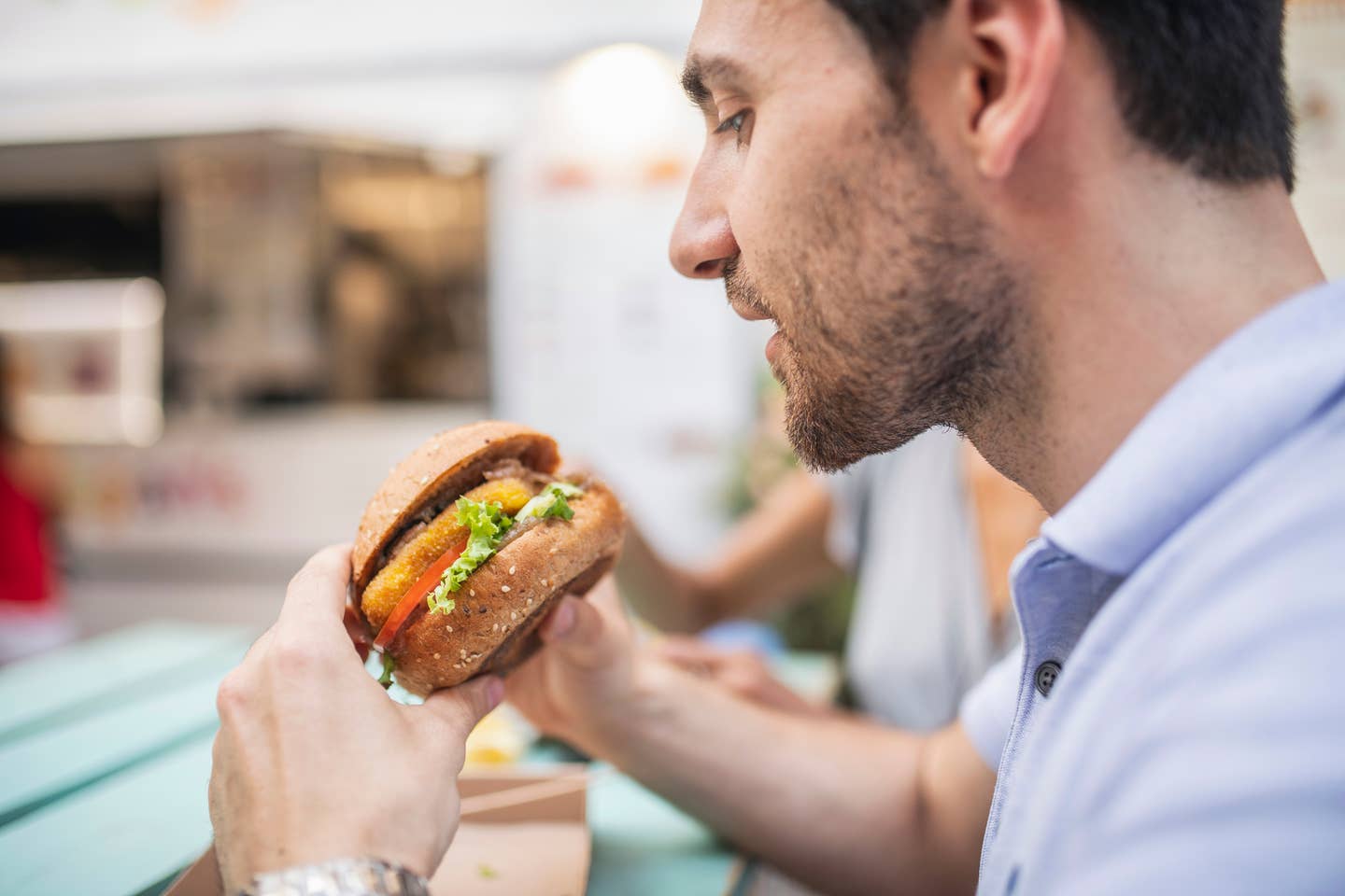 Side view angle of a Caucasian mature man eating local fast food in Budapest