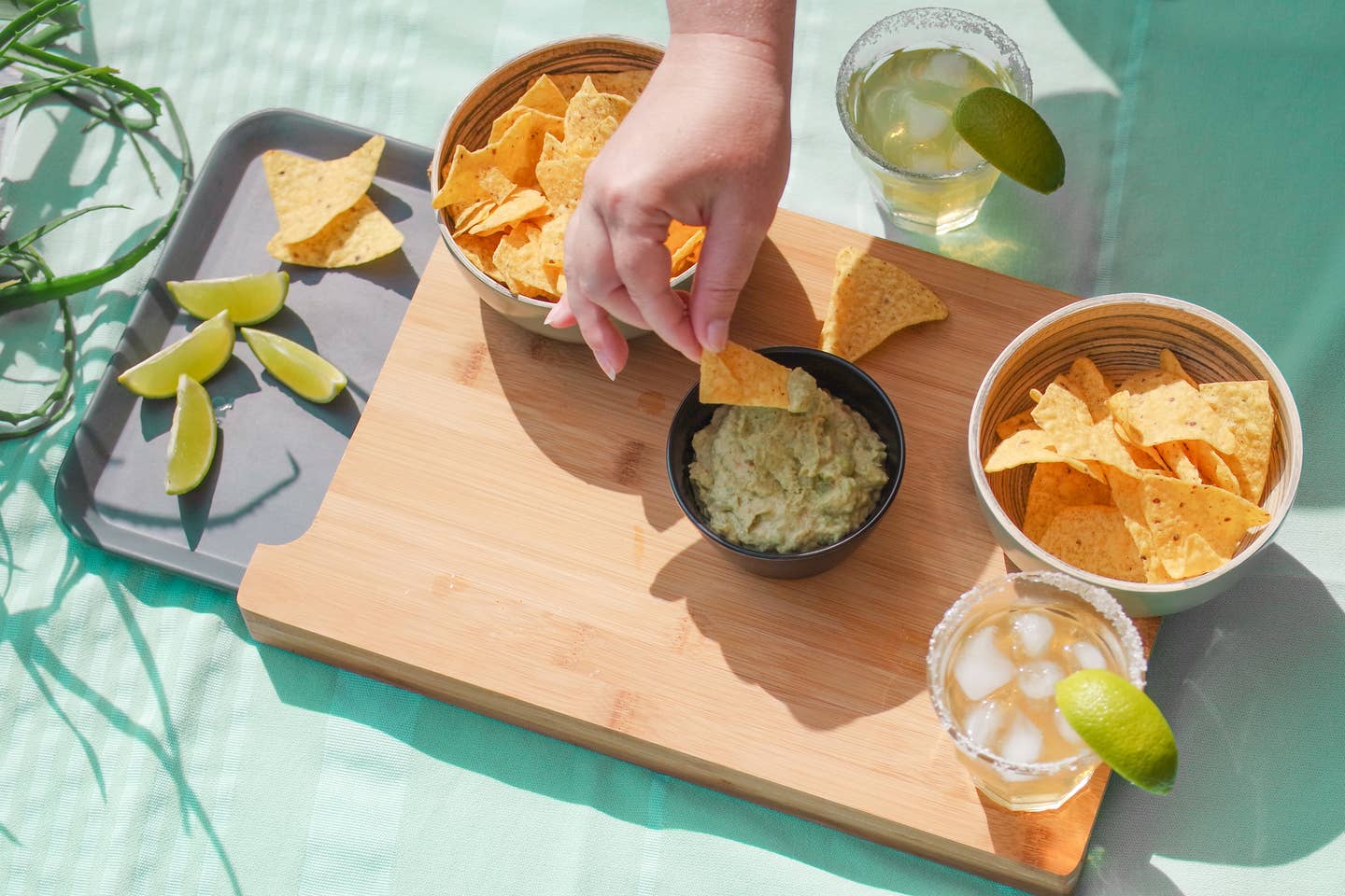 Cropped Hand Of Woman Eating Nacho Chips On Table