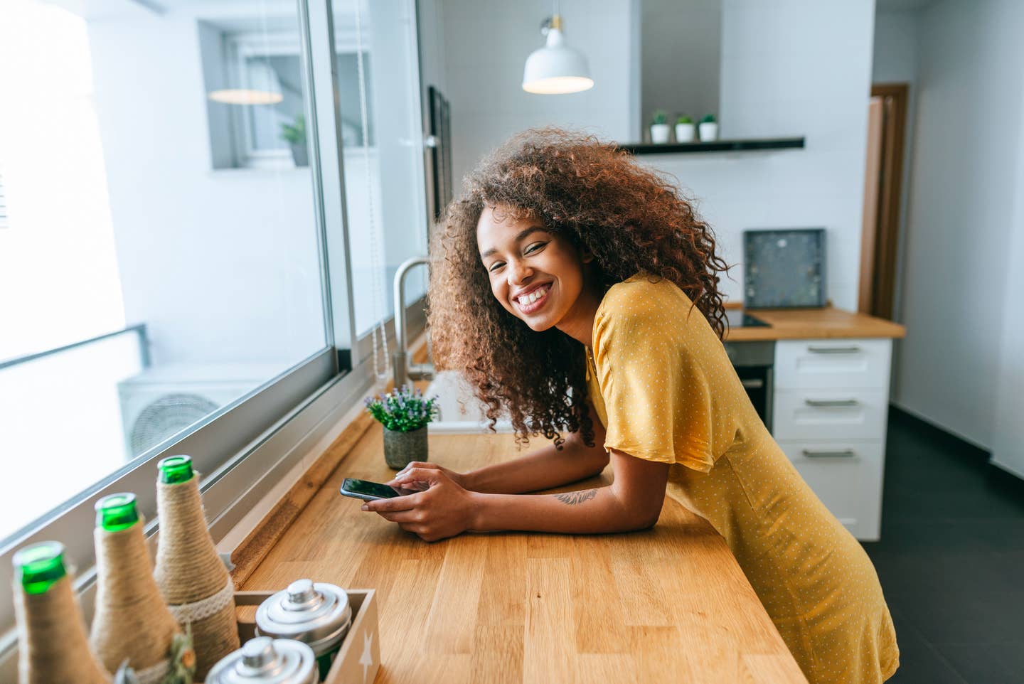 Woman using mobile phone in the kitchen