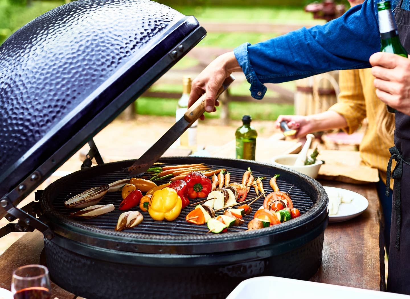 Mature man cooking vegetables on barbecue