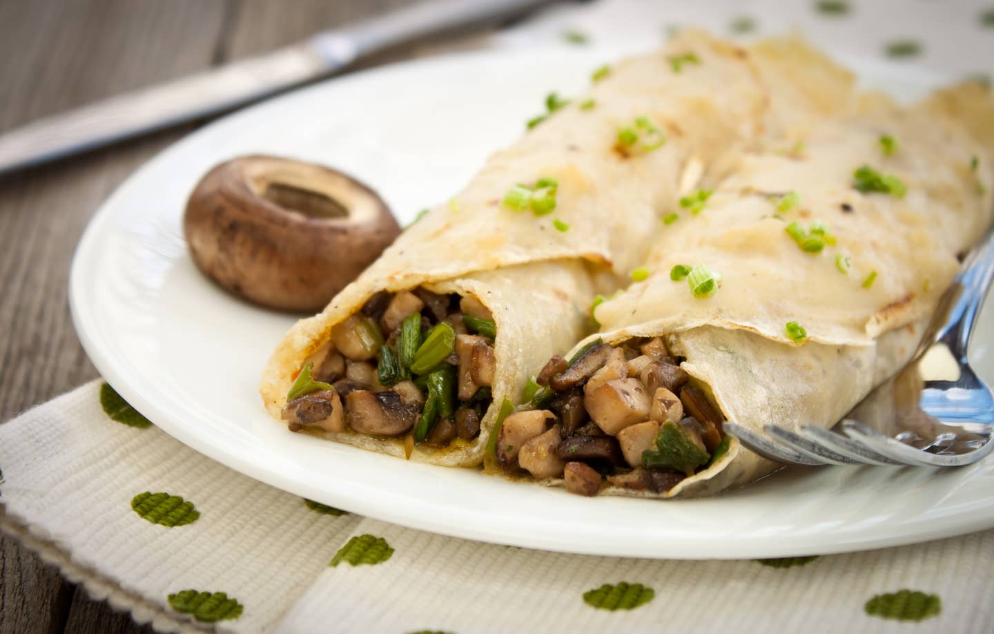 Two crepes filled with savory herbs and mushrooms