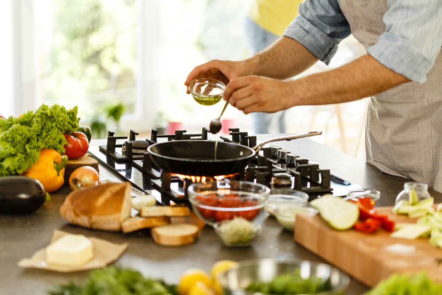 Man pouring cooking oil into frying pan