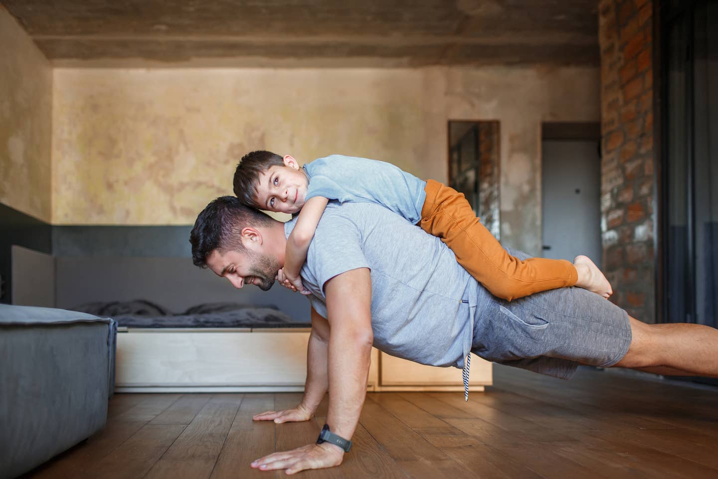 Dad and his little son play sports together